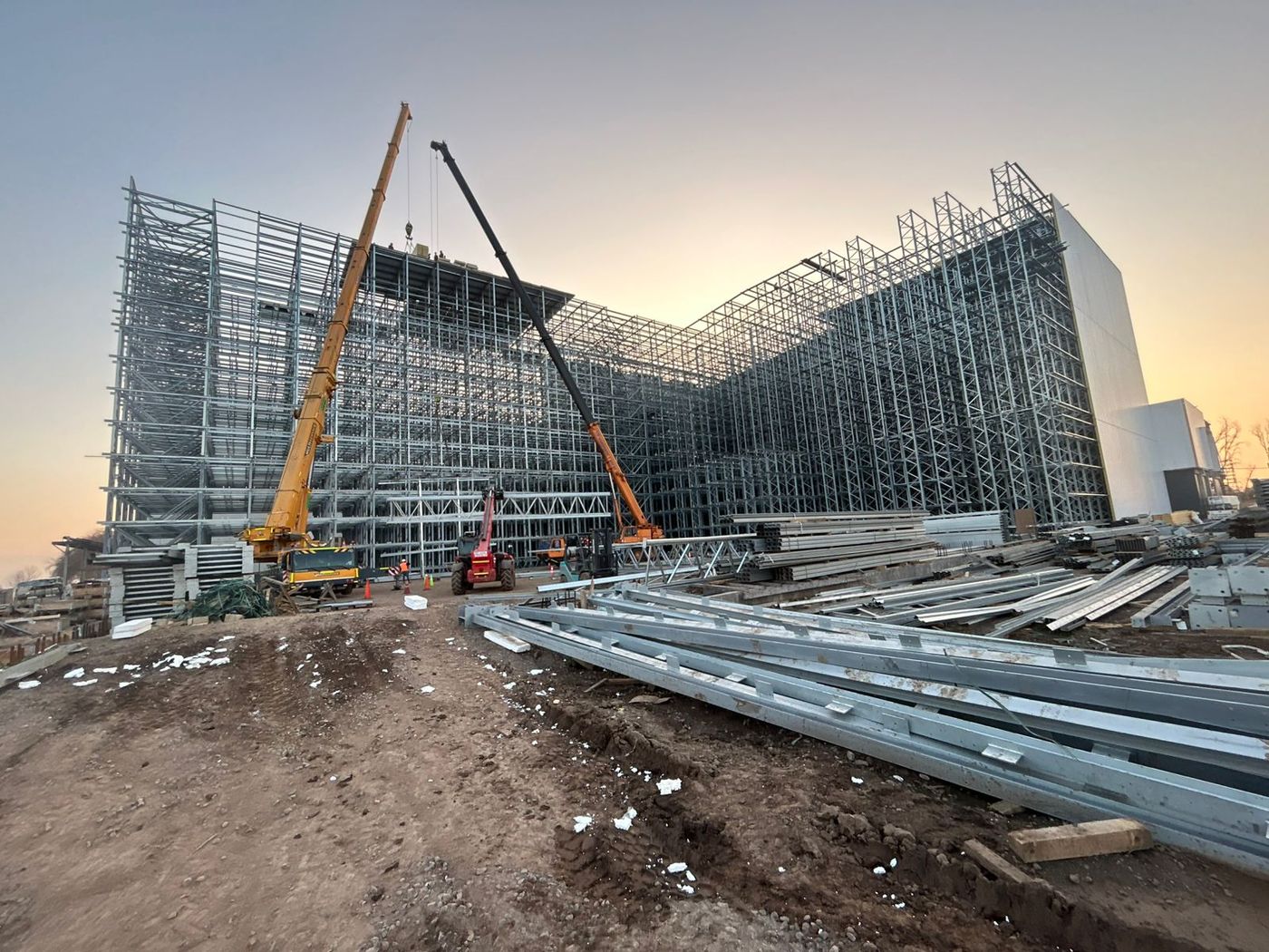 Estructura de racks en montaje con dos grúas