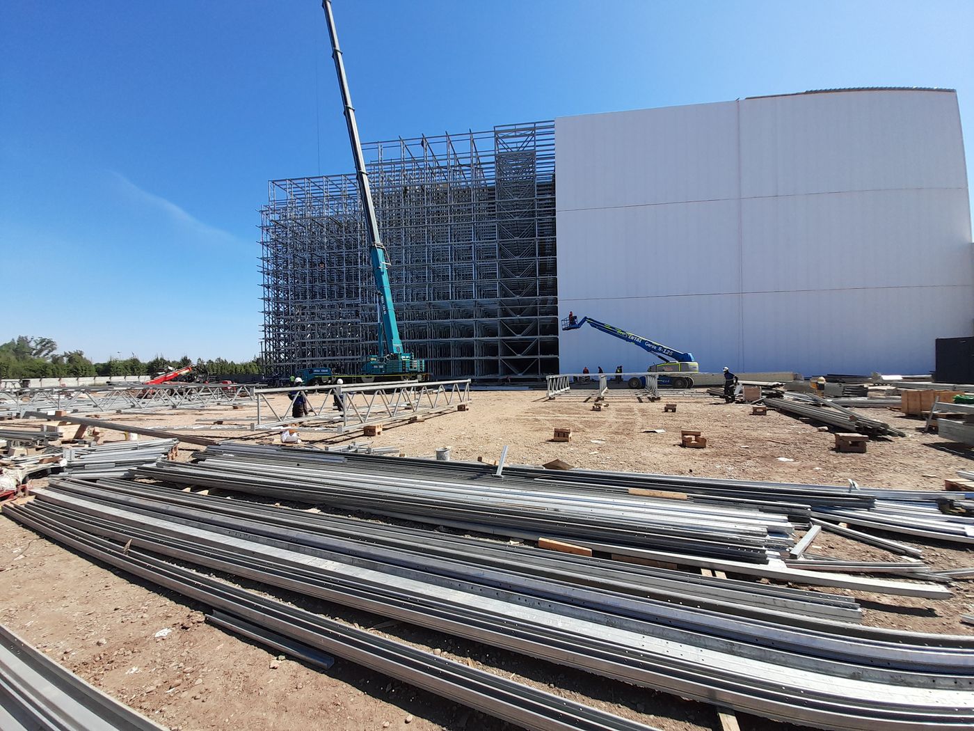 Grúa y plataforma elevadora trabajando junto a la estructura