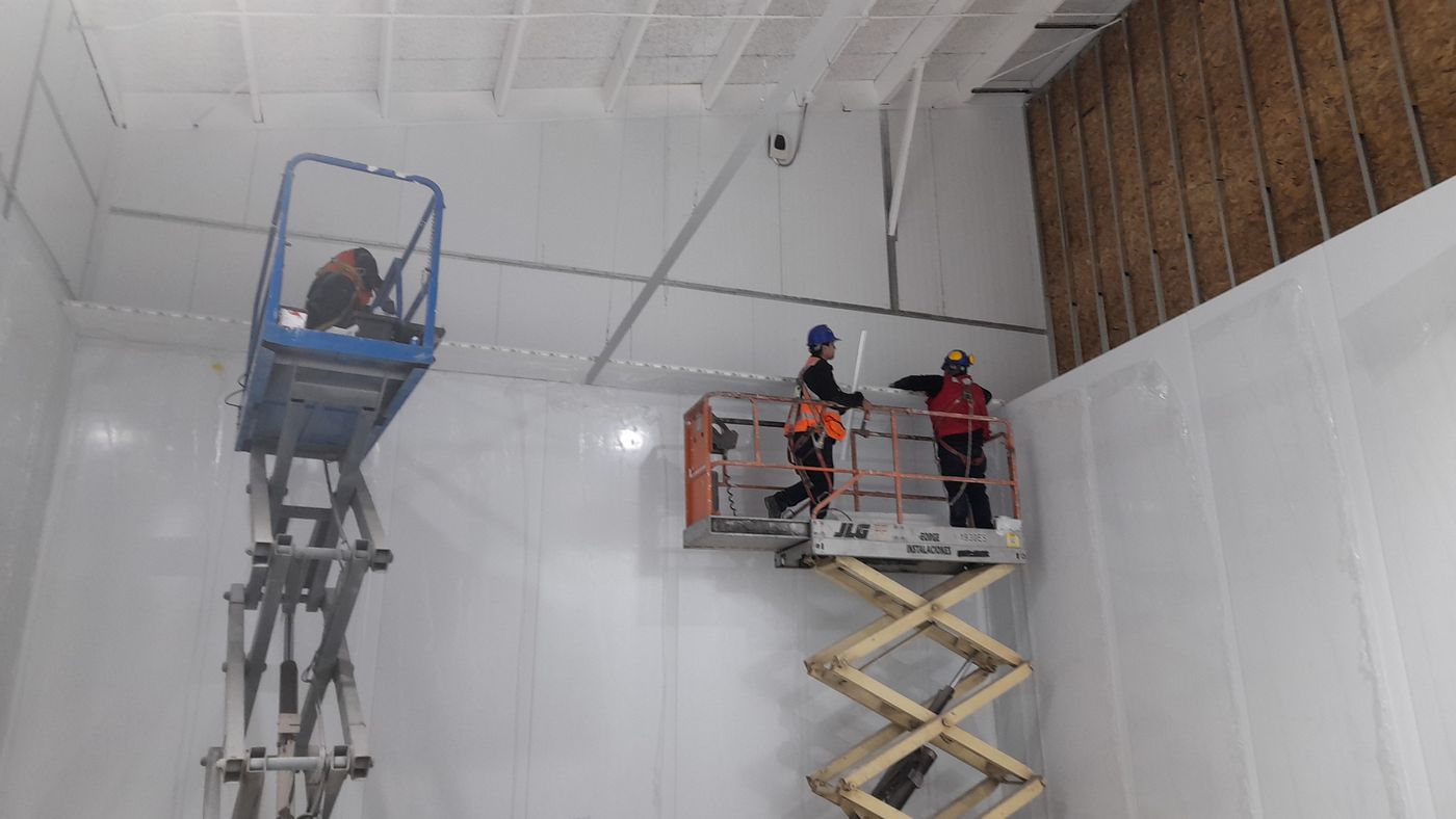 Trabajadores en plataformas de tijera dentro de una sala
